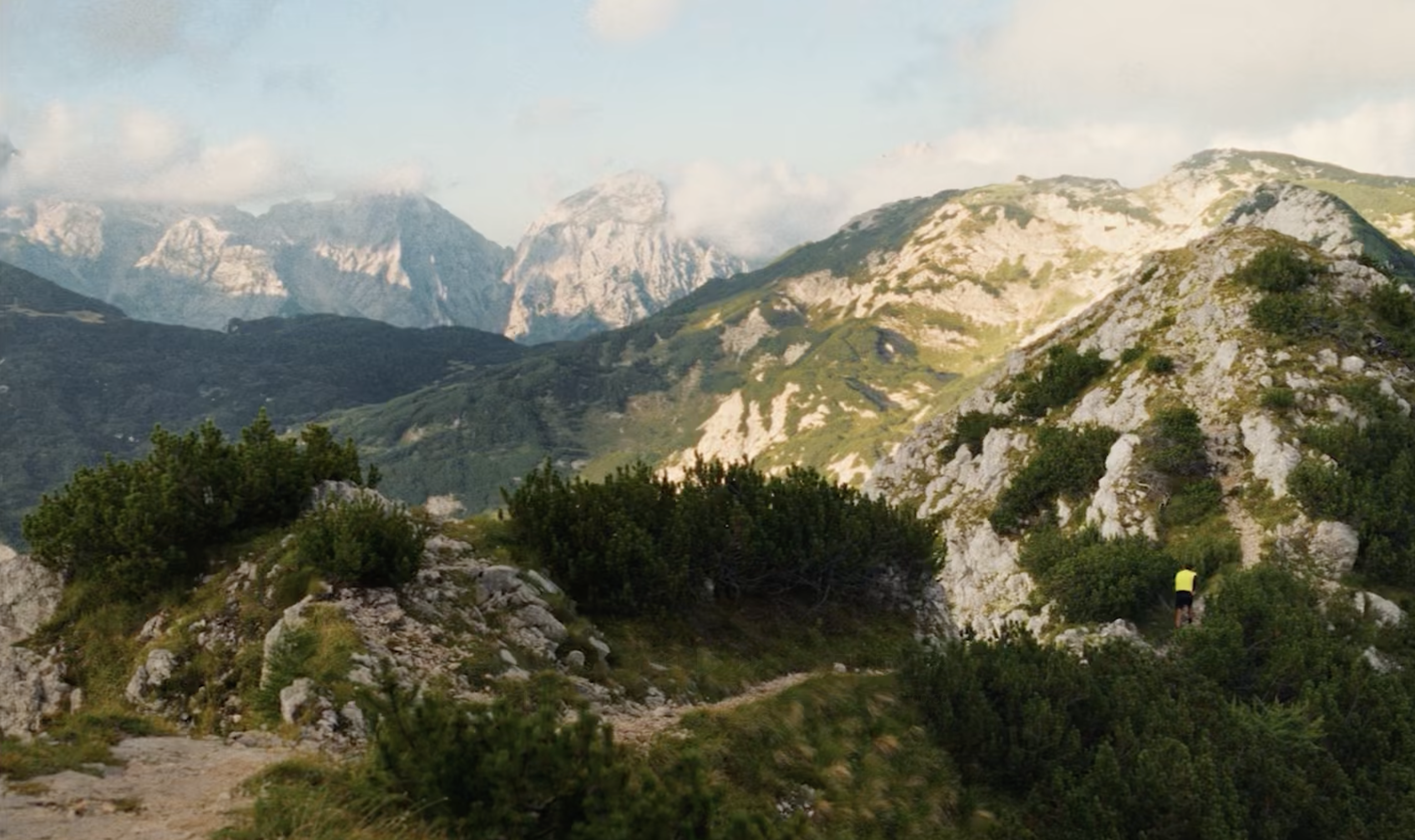 Trail runner crossing an alpine ridge at sunrise